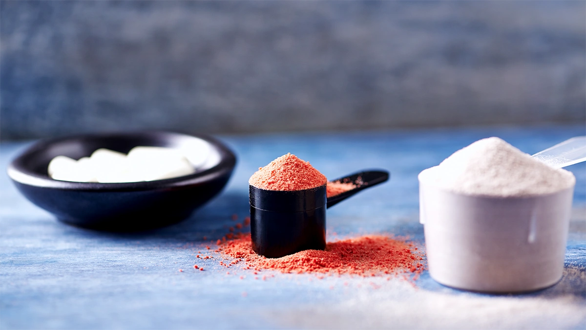 یک اسکوپ پودر وی در سمت راست و یک اسکوپ پودر گینر در کنار آن