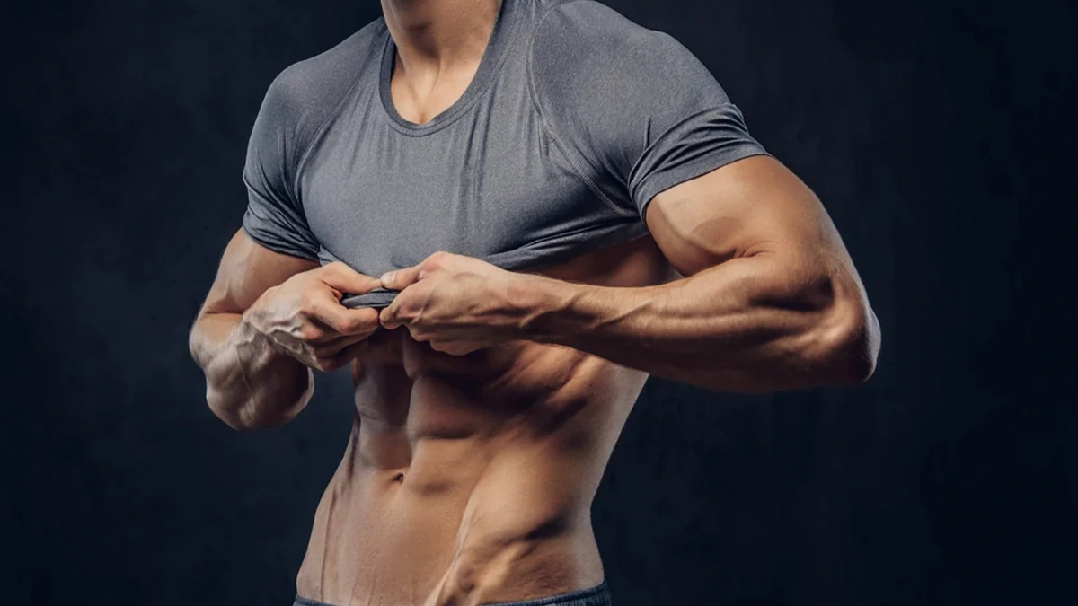 مرد لاغری که تیشرت خود را بالا زده است و شکم او سیکس پک است