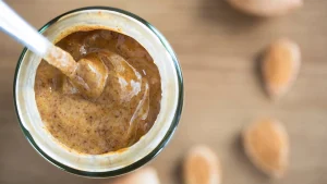 یک لیوان شیک بدنسازی حاوی بادام و موز