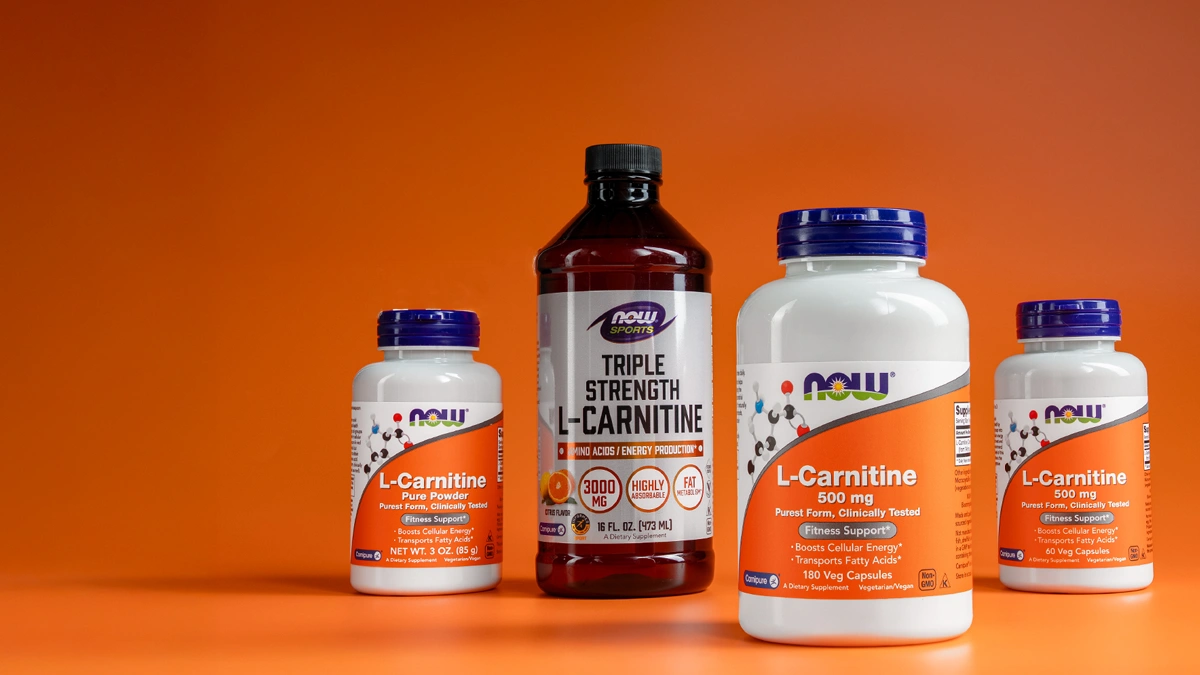 چند قوطی مکمل ال کارنیتین روی پس زمینه نارنجی