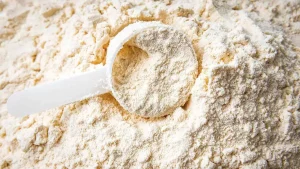 پودر وی سفید رنگ که روی سطح پراکنده شده و یک اسکوب وی هم در وسط آن قرار گرفته است