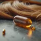 عکس یک کپسول مولتی ویتامین که پشت آن موهای بلند قهوه ای ریخته