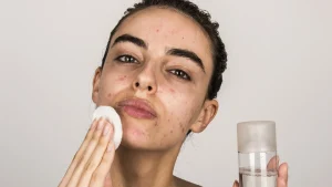 دختری که پوست صورتش چرب است و روی پوستش از شوینده استفاده می کند